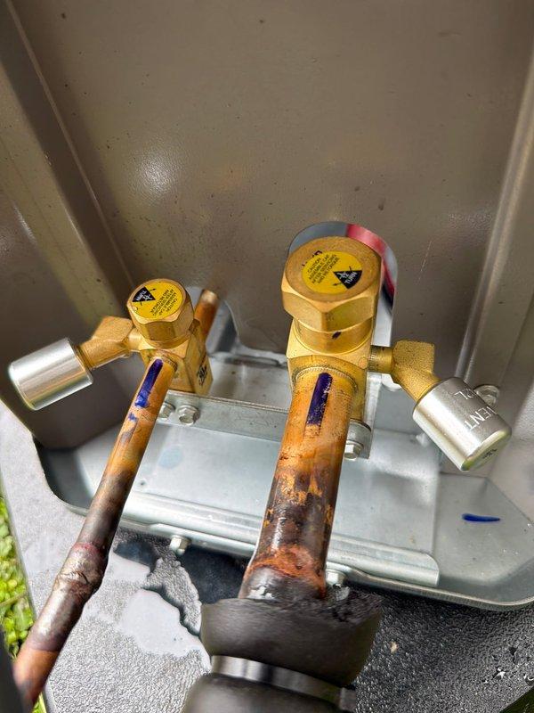 Successfully installed new 90k BTU air conditioning system, including inspection and replacement of electrical disconnect with proper 25A fuses and assessment of shut-off valves showing significant corrosion in the utility enclosure. Complete system installation verified with photographic documentation of all critical components.