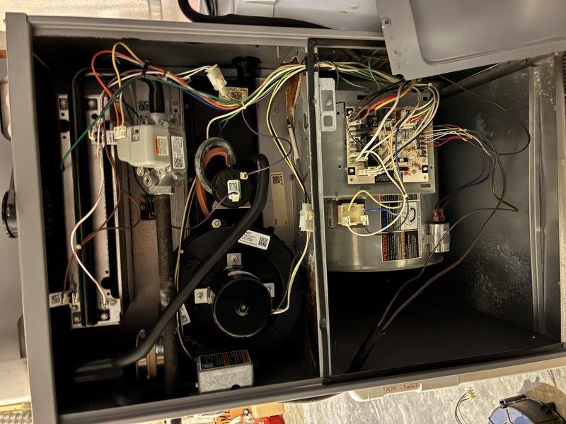 # Service Summary

Completed comprehensive furnace and air conditioning tune-up on residential HVAC system. Performed full system inspection with access panel removal to evaluate internal components, electrical connections, blower motor assembly, capacitors, control board, and heat exchanger for proper operation and safety compliance.

# Work Performed

Conducted thorough visual inspection of HVAC unit interior, examining all electrical components including wiring harnesses, connectors, and control modules. Verified proper wire routing and connection integrity across black, red, orange, yellow, green, and white conductor paths. Inspected cylindrical capacitors and circuit board terminals for signs of wear, corrosion, or thermal damage.

Evaluated blower motor assembly and associated electrical connections on left side of unit. Checked all white plastic connectors and multicolored wire bundles for secure attachment and proper condition. Assessed metallic heat exchanger component and sur