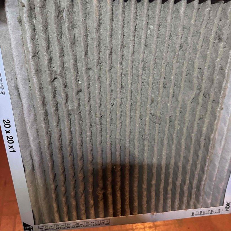 # HVAC Service Report - Heat Pump Annual Maintenance

Performed comprehensive annual tune-up on 8-10 year old outdoor heat pump system. Inspected heavily soiled air filter showing significant dust and debris accumulation with rust-colored staining in lower center section, indicating extended use beyond recommended replacement interval. Examined system control board displaying operational status code "4" on LED readout, verified proper electrical connections and wiring integrity across multiple circuit terminals and relay points. All electronic components, terminal blocks, and control circuits functioning within normal parameters at time of service.