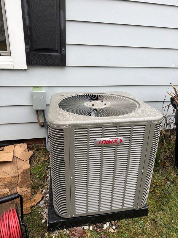 # HVAC Install - Complete System Job Description

Completed full installation of 80% AFUE gas furnace and matching air conditioning system at residential property. Installed new Lennox outdoor condensing unit on level pad against exterior wall with proper clearances maintained for airflow and service access. Unit positioned on black composite equipment pad with appropriate drainage considerations.

Performed complete electrical installation including new disconnect box mounted to exterior siding per code requirements. Installed and tested 25-amp FLNR fuses in outdoor disconnect enclosure to provide proper overcurrent protection for condensing unit. Verified all electrical connections were secure and properly terminated with appropriate wire gauges for equipment specifications.

Completed refrigerant line set installation connecting outdoor condensing unit to indoor evaporator coil. Lines properly insulated and secured along exterior wall routing. System evacuated to proper vacuum level