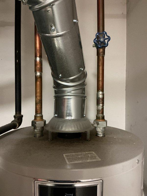 # Service Report: Tanked Water Heater Replacement

Responded to service call for 30-year-old residential water heater that had ceased producing hot water. Upon arrival and inspection, determined that the existing unit had reached end of serviceable life and replacement was the most cost-effective solution rather than repair. 

Completed full water heater replacement including removal of old unit and installation of new gas-fired tanked water heater. Work included proper connection of hot and cold water supply lines using existing copper piping infrastructure, installation of shutoff valves, and connection to existing gas supply line. Verified proper venting through existing stainless steel flue pipe system with secure connections and appropriate clearances. Installed temperature and pressure relief valve with drain line extending to floor level per code requirements. Connected all plumbing fittings and tested for leaks at all connection points.

Fired unit and verified proper ignition,