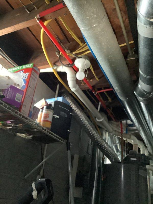 # Gas Line Electrical Bonding Installation - Historic Residential Property

Completed electrical bonding and insulation work on existing gas line system in a residential property over ninety years old. The service addressed code compliance requirements for proper electrical grounding of the gas piping infrastructure located in the basement utility area.

The installation involved bonding the yellow flexible gas line (CSST) to the building's electrical grounding system. Work included proper attachment of bonding conductors to both the flexible gas line and rigid metal gas piping components. All connections were made in accordance with current electrical and plumbing codes, which require CSST gas lines to be bonded to prevent potential electrical hazards from lightning strikes or electrical faults.

The gas line system serviced includes a red-handled shutoff valve and brass fittings connecting the flexible line to rigid metal piping. All bonding connections were installed to ensure conti