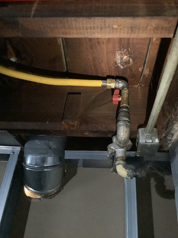 # Gas Line Electrical Bonding Installation - Historic Residential Property

Completed electrical bonding and insulation work on existing gas line system in a residential property over ninety years old. The service addressed code compliance requirements for proper electrical grounding of the gas piping infrastructure located in the basement utility area.

The installation involved bonding the yellow flexible gas line (CSST) to the building's electrical grounding system. Work included proper attachment of bonding conductors to both the flexible gas line and rigid metal gas piping components. All connections were made in accordance with current electrical and plumbing codes, which require CSST gas lines to be bonded to prevent potential electrical hazards from lightning strikes or electrical faults.

The gas line system serviced includes a red-handled shutoff valve and brass fittings connecting the flexible line to rigid metal piping. All bonding connections were installed to ensure conti