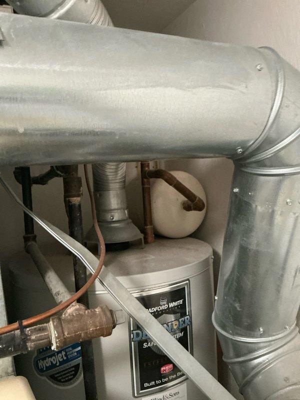 Provided comprehensive estimate for complete HVAC system replacement including furnace, air conditioning unit, whole-home humidifier, and Bradford White tankless water heater for residential property with 19-year-old existing equipment. Documented current system configuration showing existing PVC venting, ductwork connections, and mechanical room layout to ensure accurate equipment sizing and installation planning for the proposed replacement system.