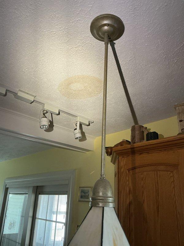 Responded to water leak complaint with visible ceiling damage in kitchen area. Upon inspection, identified water staining and discoloration on textured ceiling near light fixture and above kitchen cabinetry. Documented conditions with photographs for assessment and recommended further investigation of source above affected area to prevent additional water intrusion.