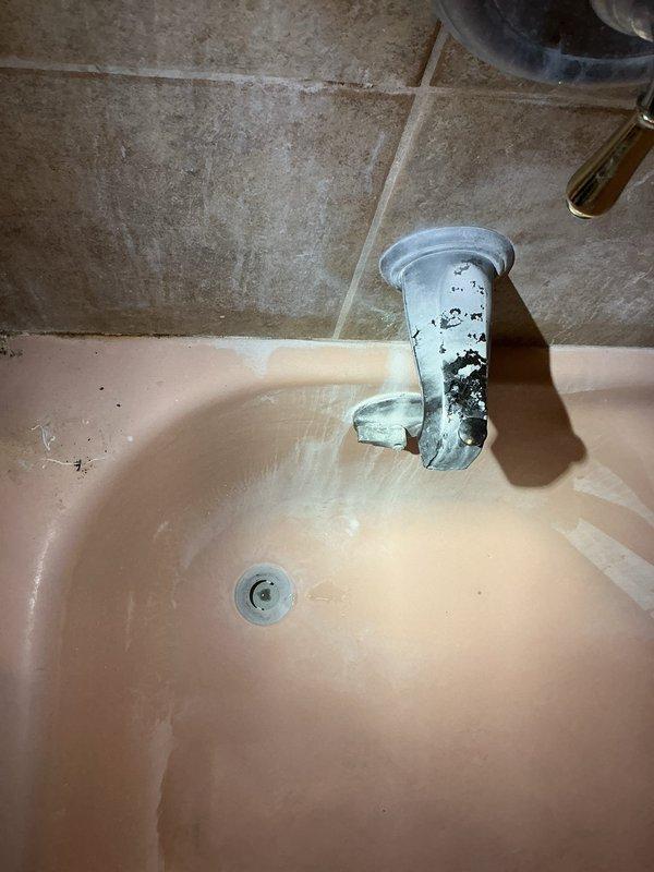 Responded to water leak complaint beneath bathtub. Upon inspection, identified deteriorated supply piping in crawl space requiring replacement along with a faulty shut-off valve. Documented existing conditions including aging plumbing fixtures, visible water staining on bathroom faucet assembly, and compromised piping connections in basement area beneath tub location. Assessed PVC drainage system and supply line configuration mounted to floor joists. Recommended complete replacement of leaking pipe section and installation of new shut-off valve to restore proper water control and eliminate active leak.