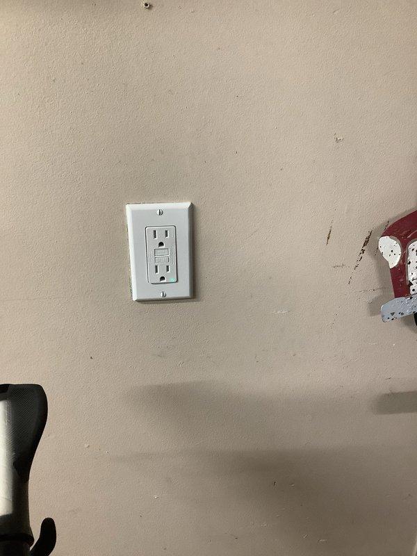 Completed comprehensive GFCI protection upgrade throughout the property. Installed bell box on exposed wire above garage door with weatherproof blank cover. Replaced faulty weather-resistant GFCI receptacle and cover at back patio door after confirming proper voltage supply. Upgraded two garage outlets to GFCI receptacles with line/load configuration. Removed existing washing machine outlet and installed 4x4 metal junction box with new GFCI outlet. Replaced three circuit breakers in main panel with GFCI breakers: 15-amp breaker at position 15, 20-amp breaker at position 16, and 15-amp breaker at position 28 to provide ground fault protection for all basement outlets. All installations tested and verified operational.