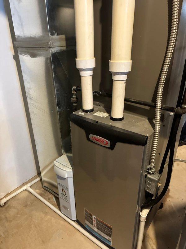 Completed comprehensive seasonal maintenance on Lennox gas furnace and Lennox air conditioning system. Performed multi-point inspection of furnace including burner assembly, heat exchanger, ignition system, and venting components. Verified proper operation of all safety controls and limit switches. Inspected PVC intake and exhaust venting for proper installation and clearances. Evaluated outdoor condensing unit including compressor operation, condenser coil condition, and refrigerant pressures. Cleaned condenser coil and verified adequate airflow through louvered panels. Checked electrical connections, capacitor readings, and contactor condition on both units. All systems operating within manufacturer specifications with no deficiencies noted.