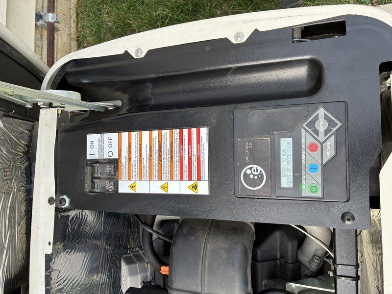 Performed routine maintenance on a 5-year-old 16KW Generac natural gas standby generator. Removed previous service company decals and applied new identification stickers to the unit. Inspected all accessible components including control panel, circuit breakers, ON/OFF switch, and status indicator lights, confirming proper operational condition of the generator system.