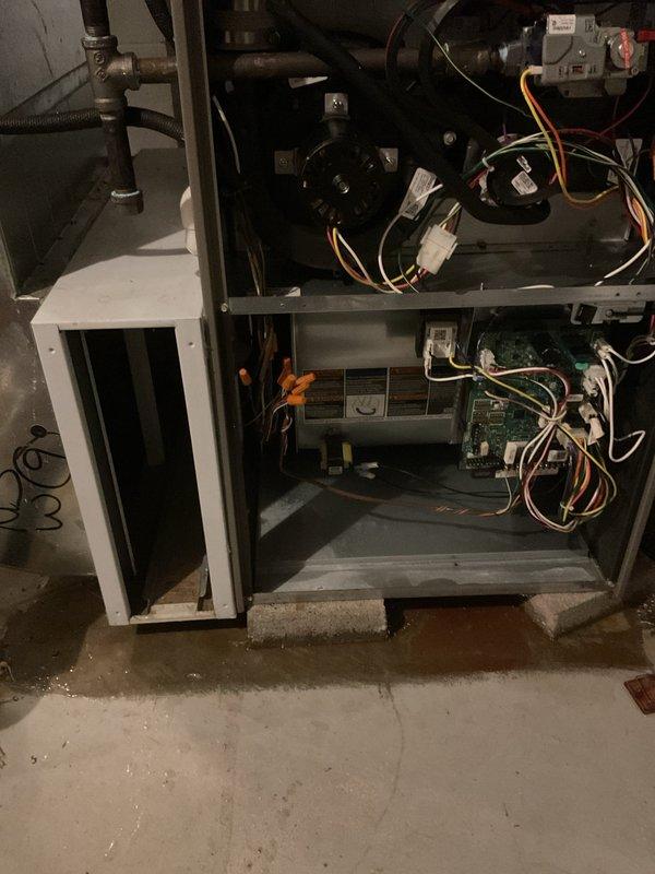 Responded to water leak in basement originating from HVAC humidifier system. Upon arrival, found significant water pooling on concrete floor near foundation window area and traced source to humidifier unit integrated with furnace system. Opened access panel on HVAC unit and inspected humidifier components, water supply line, and drain connections. Identified failed solenoid valve on humidifier water feed line causing continuous water flow and overflow condition. Replaced defective solenoid valve, tightened all water line connections, and verified proper drainage through humidifier drain line. Tested system operation through multiple heating cycles to confirm leak was resolved and no additional water discharge occurred. Documented existing moisture damage on basement floor and recommended monitoring area for proper drying. System restored to normal operation with no further water leakage detected.