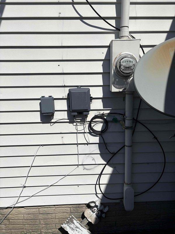 Completed electrical estimate for Generac generator installation at residential property. Assessed existing electrical service entrance, metering equipment, and available space for generator placement in side yard area between house and garage. Documented current electrical panel configuration and utility connections to determine requirements for automatic transfer switch installation and integration with existing 200-amp service. Confirmed propane fuel source will be required as natural gas is not available at this location. Photographed meter base, service entrance conductors, and proposed generator location to develop comprehensive installation plan and material list for whole-house backup power system.