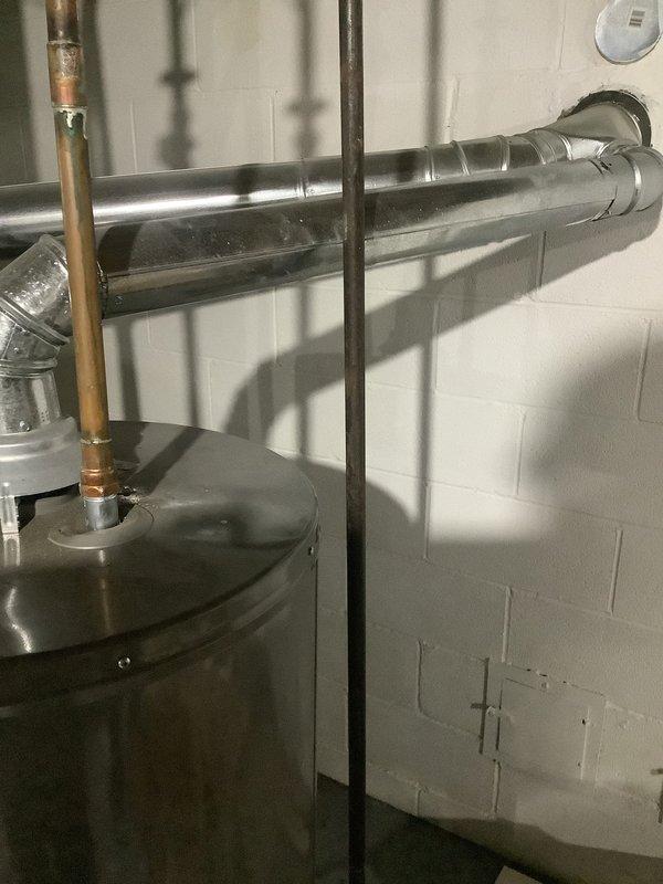 Responded to service call for leaking hot water tank with no hot water availability. Upon inspection, confirmed active leak from existing tanked water heater and complete loss of hot water supply. Evaluated mechanical room configuration, existing plumbing connections including copper supply lines, gas piping with sediment trap, and electrical connections. Provided comprehensive estimate for conventional tanked water heater replacement as well as alternative tankless water heater installation option. Documented existing system layout including shut-off valves, pressure relief components, and venting configuration through photographic records for replacement planning and same-day installation coordination.