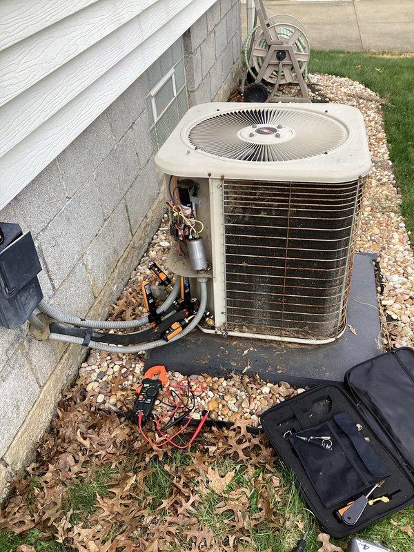 Completed preventive maintenance tune-up on residential air conditioning system. Removed condenser top panel, performed electrical diagnostics with digital clamp meter reading 6.44 amps, and inspected refrigerant lines and internal components. All system parameters tested within normal operating range.