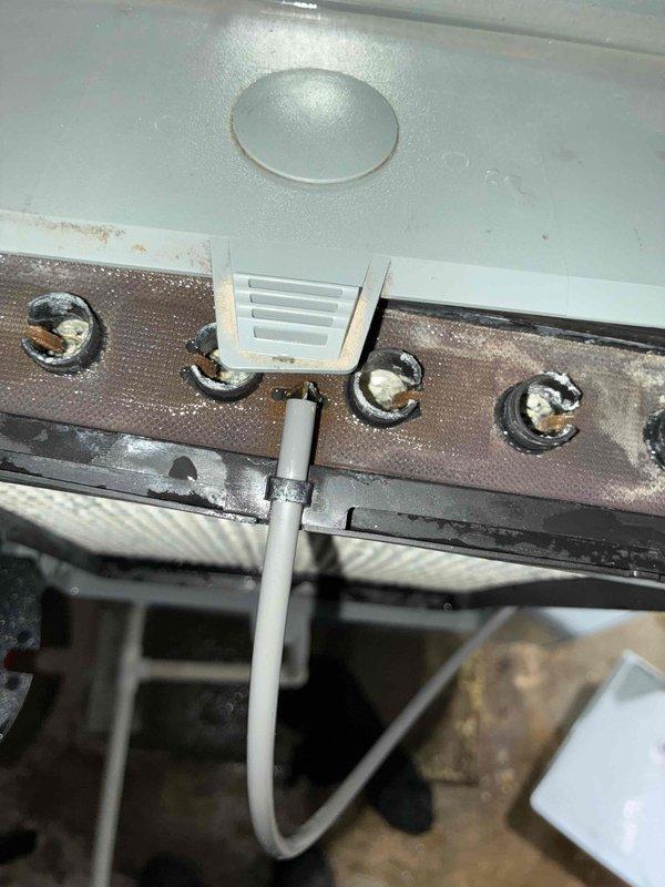 Responded to service call for leaking humidifier on HVAC system. Upon inspection, discovered significant rust and corrosion on the humidifier mounting bracket and water distribution components. The leak originated from deteriorated water feed line connections and corroded metal surfaces that had compromised the unit's water containment integrity. Documented existing conditions with photos showing extensive rust damage on horizontal support bracket and aging filter assembly. Performed diagnostic evaluation and provided customer with repair options and recommendations for addressing the moisture infiltration issue to prevent further system damage.