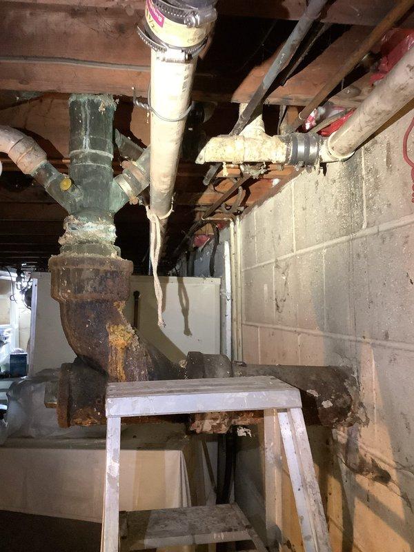 Replaced deteriorated sections of PVC drainage piping in basement, eliminating all rubber connections from stack tie-in point back to kitchen sink riser. Reworked lavatory sink drain line to proper configuration, replacing improper existing connections with code-compliant PVC fittings and pipe. All work completed with new Schedule 40 PVC materials; however, due to pre-existing condition of main stack showing significant corrosion, integrity of adjacent original piping cannot be guaranteed.