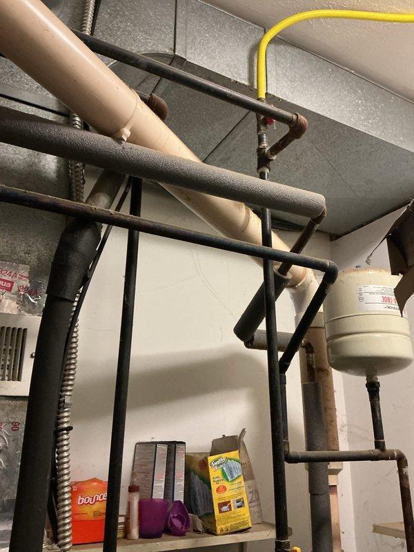 # Tanked Water Heater Service Call

Responded to service call for hot water tank issue in residential utility room. Performed diagnostic inspection of water heater unit located in basement mechanical space adjacent to HVAC furnace and laundry appliances. Assessed water heater condition, examined plumbing connections, and verified proper operation of heating elements and temperature controls. Inspected associated piping infrastructure including supply lines and drainage systems visible in utility area. Completed necessary repairs to restore hot water heater to proper working condition. Unit tested and confirmed operational upon completion of service work.