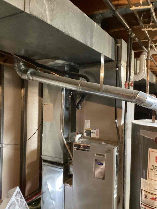 Completed Early Bird Tune-Up on 17-year-old Carrier HVAC system. Performed comprehensive inspection of furnace unit, ductwork, and air conditioning components in basement mechanical installation. Inspected electrical contactor assembly, verified wire connections on terminals, and examined capacitor condition. All components functioning within normal parameters for unit age, with typical wear and dust accumulation noted on electrical housing and terminals.