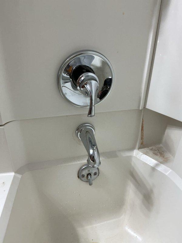 Completed installation of customer-supplied Moen lavatory faucet with new shut-off valves, P-trap, and supply lines. Created wall access opening in hallway behind tub shower area and installed access panel for future maintenance accessibility. In basement drop ceiling, installed two new ball valves on hot and cold water supply lines. Ran new copper risers from basement to bathroom and installed necessary pipe fittings to accommodate new fixture configuration. Installed customer-supplied Moen tub shower valve body and completed trim installation including single-handle control valve, tub spout with diverter, and shower head assembly. All fixtures tested for proper operation and verified no leaks at connections. Chrome finishes properly aligned and secured to wall surfaces.