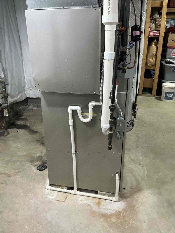 Completed dual system HVAC replacement estimate for furnace and air conditioning units. Assessed existing furnace installation in basement utility area, including current PVC condensate drainage configuration, refrigerant line routing, and electrical connections. Evaluated second system location in unfinished residential space with exposed framing and determined equipment placement, ductwork modifications, and infrastructure requirements for new installation.