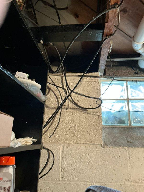 Conducted comprehensive site assessment for backup generator installation. Evaluated existing electrical infrastructure in basement utility area, documenting current wiring configuration and available space for transfer switch placement. Inspected exterior electrical service entrance and metering equipment to determine load capacity and optimal connection point for generator tie-in. Photographed existing conditions including basement electrical routing, overhead conduit pathways, and main service meter location on exterior brick wall. Assessment included verification of available circuit breaker panel capacity and identification of critical circuits for emergency power backup. Prepared documentation for generator system sizing, transfer switch specifications, and installation requirements based on observed site conditions.