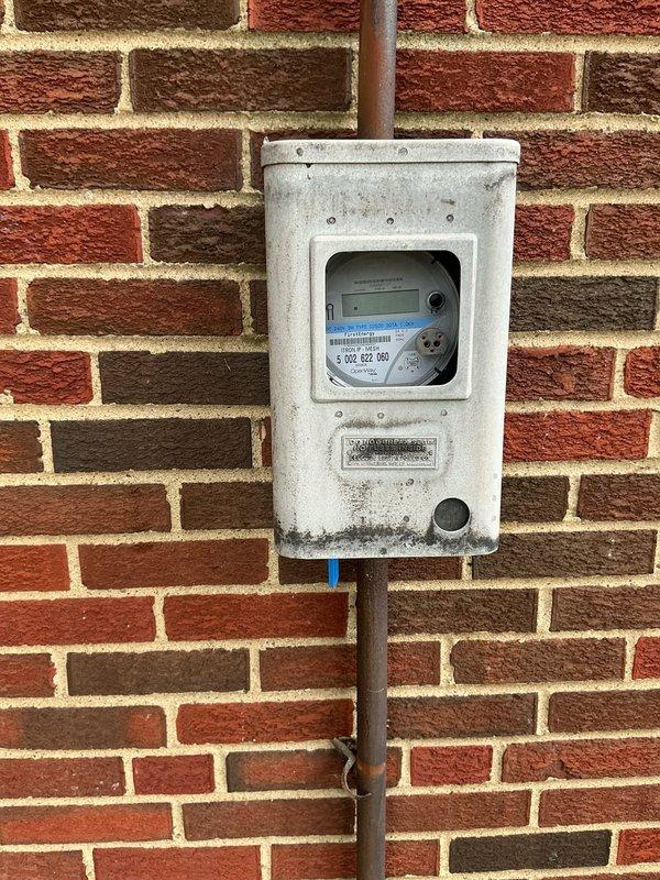 Conducted comprehensive site assessment for backup generator installation. Evaluated existing electrical infrastructure in basement utility area, documenting current wiring configuration and available space for transfer switch placement. Inspected exterior electrical service entrance and metering equipment to determine load capacity and optimal connection point for generator tie-in. Photographed existing conditions including basement electrical routing, overhead conduit pathways, and main service meter location on exterior brick wall. Assessment included verification of available circuit breaker panel capacity and identification of critical circuits for emergency power backup. Prepared documentation for generator system sizing, transfer switch specifications, and installation requirements based on observed site conditions.