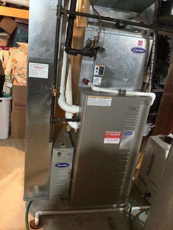 Conducted replacement estimate for approximately 18-year-old residential HVAC system in single-family home. Evaluated existing Carrier furnace and air handler installation in basement utility area, documented current equipment configuration including vertical stacking arrangement, PVC condensate drainage, and ductwork connections. Photographed system components and provided replacement recommendations based on equipment age and condition assessment.