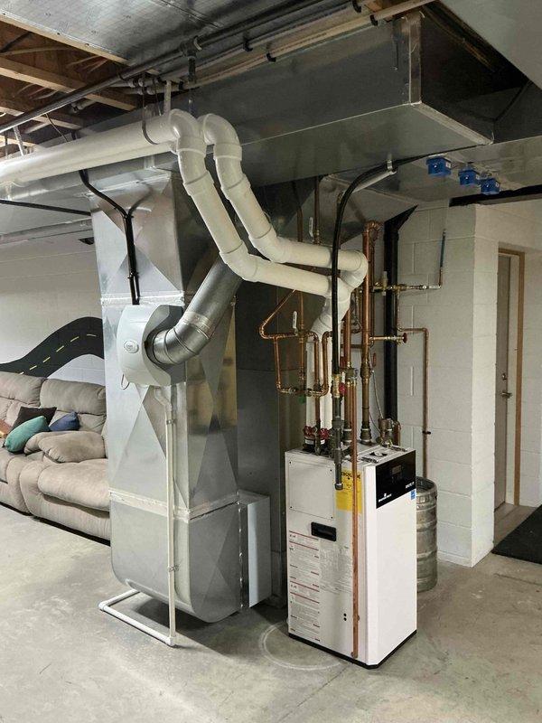 Conducted comprehensive site assessment for multi-zone HVAC system replacement including furnace, air conditioning, and heat pump equipment. Evaluated existing Carrier furnace/air handler installation, documented current ductwork configuration with metallic supply ducts and flexible connections, and assessed mechanical room infrastructure including electrical conduit routing, copper refrigerant line placement, and PVC condensate drainage. Inspected secondary heating system with associated copper piping and determined spatial requirements for new equipment installation in basement mechanical room with consideration for existing boiler system and available clearances.