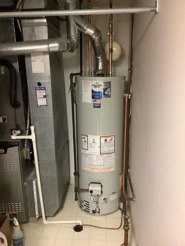 Installed a new 40-gallon tall Bradford White automatic storage water heater with 10-year warranty in residential utility room. Installation included 3/4-inch ball valve for shutoff control, 3/4-inch thermal expansion tank to protect against pressure buildup in closed plumbing systems, proper electrical bonding of water heater per code requirements, and connection of copper supply lines with appropriate fittings. Unit was installed adjacent to existing HVAC equipment, with all safety labels and manufacturer specifications clearly visible and intact upon completion.