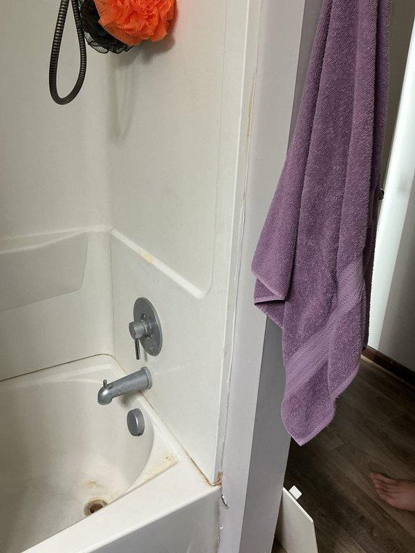 Responded to service call for leaking shower/tub seal. Conducted on-site inspection and provided free estimate as alternative to full shower replacement that customer had previously been quoted. Evaluated bathtub and shower combination unit with white fiberglass surround to assess seal integrity and determine source of water intrusion. Documented existing conditions with photographs for estimate purposes. Customer seeking more cost-effective repair solution rather than complete fixture replacement.