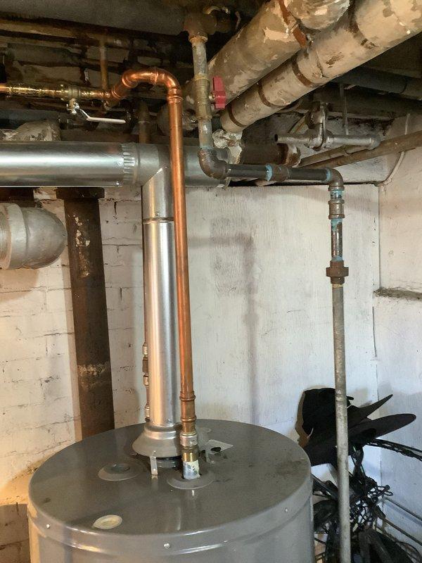 Responded to main drain line stoppage at century-old single-family residence requiring cleanout from house to street connection. Upon arrival, discovered significant deterioration in basement utility area including damaged concrete floor with large opening near wall intersection, extensive moisture staining, and compromised wall surfaces indicating long-term water infiltration issues. Successfully cleared main sewer line obstruction using professional drain cleaning equipment. Documented existing conditions including water heater installation, overhead plumbing infrastructure, and basement structural concerns for homeowner records and potential future remediation needs.