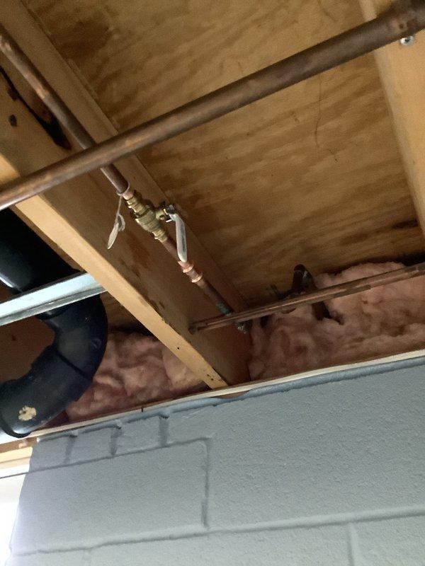 Responded to a leaking interior shut-off valve serving an outdoor spigot line. Located the valve in the crawl space among exposed copper piping and structural framing. Replaced the faulty shut-off valve with a new brass ball valve, ensuring proper connection to the existing copper supply line. Tested the system for leaks and verified proper operation of the valve mechanism. The outdoor spigot line is now isolated and functioning without leakage.