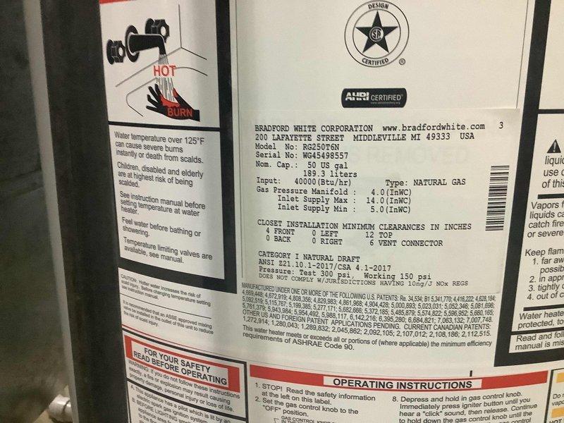 Responded to service call for water heater inspection following HVAC technician's referral. Upon arrival, performed comprehensive evaluation of Bradford White 50-gallon natural gas water heater, model RG450T6N with 40,000 BTU/hr input rating. Documented equipment condition through photographic inspection, noting significant corrosion buildup at copper pipe brass connector on hot water outlet. Observed condensation present on galvanized vent pipe and confirmed all manufacturer specification labels and safety warnings intact and legible. Verified proper clearances for closet installation per ANSI standards. Equipment operational at time of inspection with all connections and fittings accessible for maintenance.