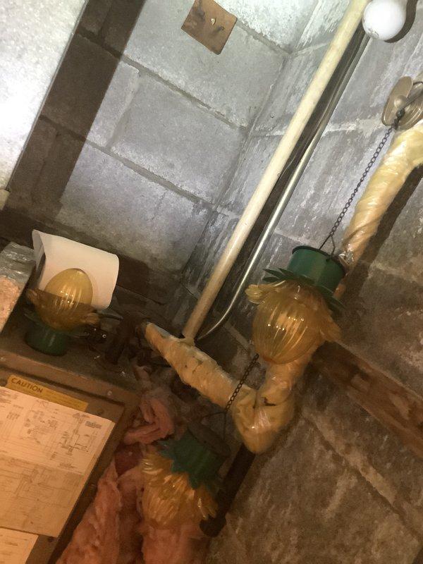 Performed comprehensive assessment of existing package unit system for replacement estimate. Inspected attic-mounted electrical junction box with metal conduit connections, noting accumulated debris and exposed infrastructure. Evaluated basement mechanical room plumbing components including insulated piping with gate valves showing age-related wear and discoloration. Documented all equipment conditions and system configurations through photographic documentation to provide accurate replacement specifications and scope of work for new package unit installation.