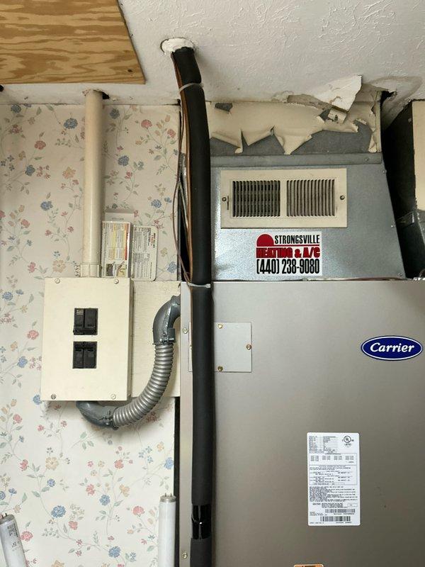 Conducted comprehensive HVAC system evaluation for complete equipment replacement at residential property. Assessed existing Carrier brand condensing unit positioned on exterior concrete pad with proper electrical disconnect and refrigerant line routing, as well as indoor air handling equipment in basement utility area. Documented current system configuration, equipment specifications, and installation conditions through detailed photography to provide accurate replacement estimate for new heating and cooling system.