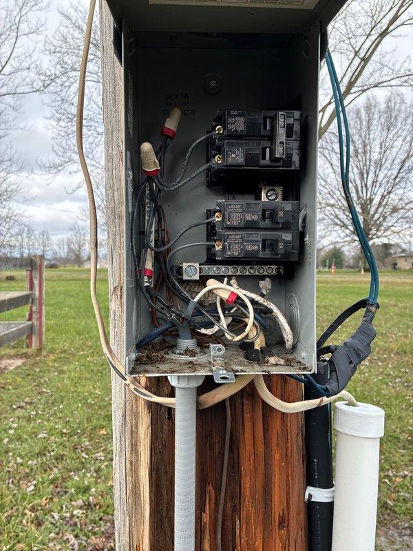 Replaced deteriorated service entrance cable (SEU) and weather head on outdoor utility pole-mounted electrical service panel. Removed old weathered wiring and conduit showing signs of insulation degradation, installed new service entrance conductors, PVC conduit, and weather head assembly. Verified all connections within panel enclosure, secured new wiring with appropriate fasteners, and ensured proper routing of cables down pole structure to maintain code compliance and weather protection.
