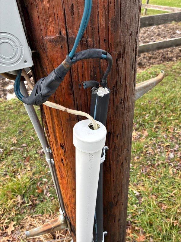 Replaced deteriorated service entrance cable (SEU) and weather head on outdoor utility pole-mounted electrical service panel. Removed old weathered wiring and conduit showing signs of insulation degradation, installed new service entrance conductors, PVC conduit, and weather head assembly. Verified all connections within panel enclosure, secured new wiring with appropriate fasteners, and ensured proper routing of cables down pole structure to maintain code compliance and weather protection.