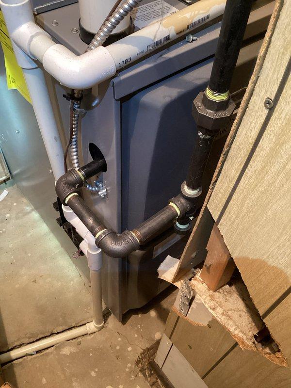 Responded to service call for loud furnace operation. Upon inspection, documented existing plumbing and venting configuration connected to heating system. Captured photographic documentation of installation showing PVC vent piping, flexible gas connector, and associated mechanical connections for service records.