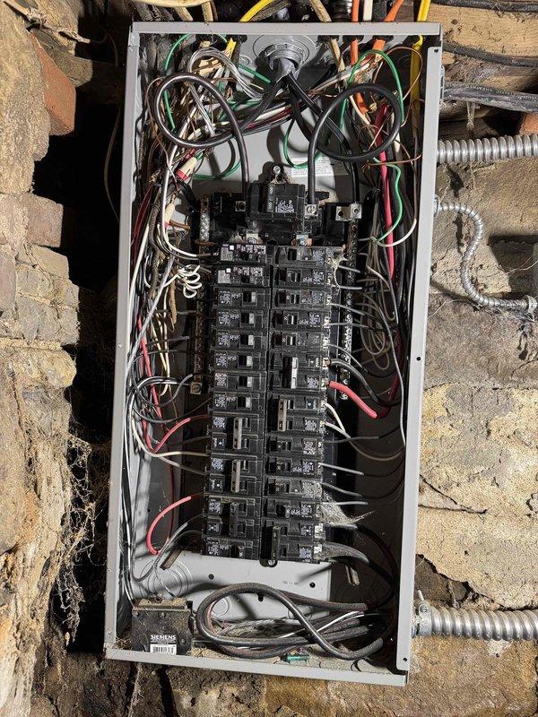 Replaced the exterior electrical panel and installed new ground rods to establish proper grounding for the residential electrical system. Installed an exterior disconnect switch to meet current code requirements and mounted a whole home surge protection device to safeguard the home's electrical equipment from voltage spikes. All circuit breakers were properly connected and the panel was secured to the exterior brick wall with appropriate weatherproof protection.