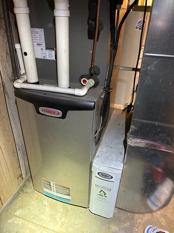 Completed annual maintenance on 3-year-old Lennox furnace and air conditioning system. Inspected evaporator coil filter showing dust accumulation on lower portion, checked all mechanical components, verified proper operation of heating and cooling equipment, and documented system condition with photos. Customer requires MVP renewal at this time.