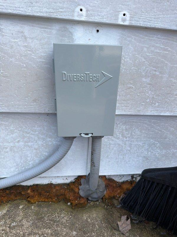 Completed full HVAC system installation including new air handler and heat pump unit. Installed DiversiTech electrical disconnect box on exterior wall with proper conduit routing to ground level, ensuring secure mounting to building siding and code-compliant electrical connections. Replaced dual-element fuses in disconnect assembly with FLNR-rated copper fuse cartridges for proper overcurrent protection of the new equipment.