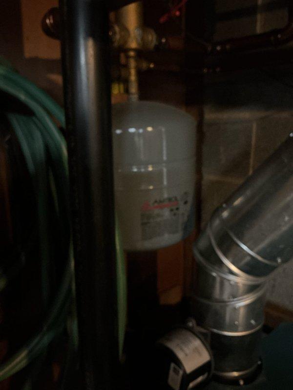 Replaced failed pressure reducing valve (PRV) with new unit and installed ball valve for improved system isolation and maintenance access. Removed old expansion tank and installed new replacement tank to maintain proper system pressure control and prevent thermal expansion damage to plumbing system. All copper connections were properly fitted and secured, with components mounted to concrete block wall using appropriate brackets and supports.