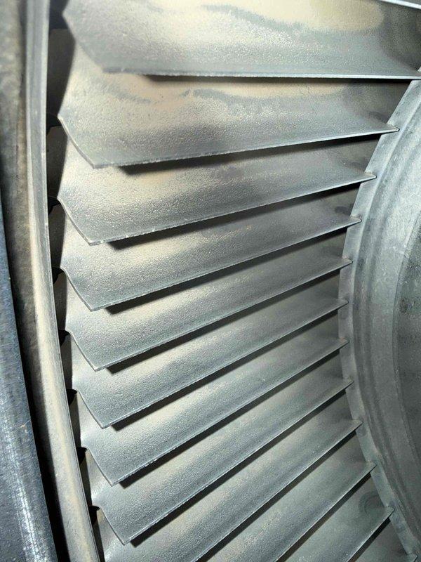 Completed scheduled BS-MVP heating maintenance visit and performed comprehensive system inspection. Documented evaporator coil condition showing significant frost accumulation on heat exchanger fins, indicating active refrigeration cycle operation. Photographed interior components including corrugated metal housing panels and coil assembly within confined vertical channel space to verify proper system operation and identify any maintenance concerns.