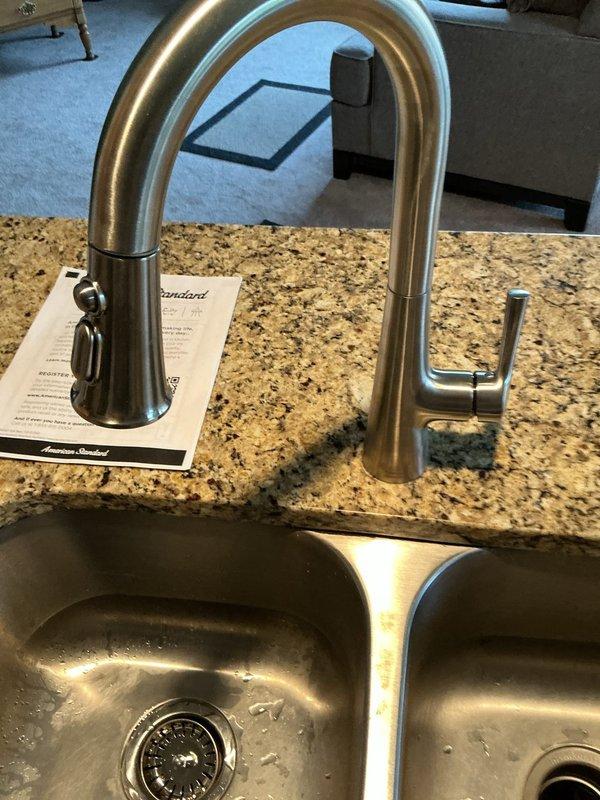Successfully installed customer-supplied kitchen faucet with single-handle design and brushed stainless steel finish on granite countertop. Replaced basket strainer assembly on left basin of double-bowl stainless steel sink, ensuring proper seal and drainage function. Both installations completed using customer-provided fixtures and materials.
