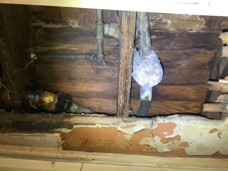 Responded to bathtub drainage concern in century-old residence where customer reported possible blockage and visible hole in drain line beneath tub. Accessed crawl space beneath bathroom fixture to inspect drain assembly and trap configuration. Upon inspection, identified compromised drain piping with deterioration evident in the drainage system, along with aged plumbing components consistent with the structure's age. Documented existing conditions through photography showing exposed drain lines, trap assembly, and surrounding structural elements in the under-floor cavity. Assessed entire visible drain line run for additional damage, corrosion, or integrity issues that could contribute to drainage problems or future failures. Provided customer with findings regarding the damaged drain line section and recommendations for necessary trap replacement and drain line repairs to restore proper function and prevent water damage to floor structure and surrounding areas.