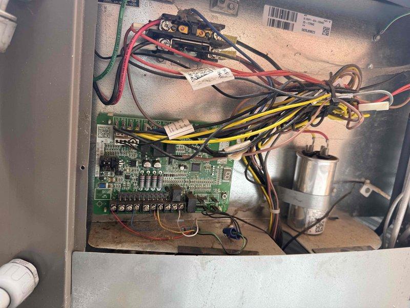 Performed scheduled maintenance on a 4-year-old Lennox heat pump system. Inspected outdoor unit exterior, which showed weathering and algae buildup on top panel and housing. Accessed electrical control panel and verified all wire connections, circuit board components, and capacitor were secure and functioning properly. System operational upon completion of maintenance inspection.
