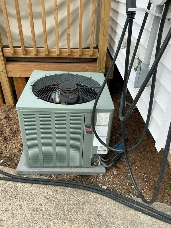 Conducted on-site evaluation for replacement estimate of residential split HVAC system, including both furnace and air conditioning unit, both approximately 10 years old. Assessed existing equipment configuration consisting of basement-installed forced air furnace with plenum assembly and exterior-mounted AC condenser unit positioned beneath wooden deck structure. Documented current system specifications, installation conditions, and equipment placement for comprehensive replacement proposal development.