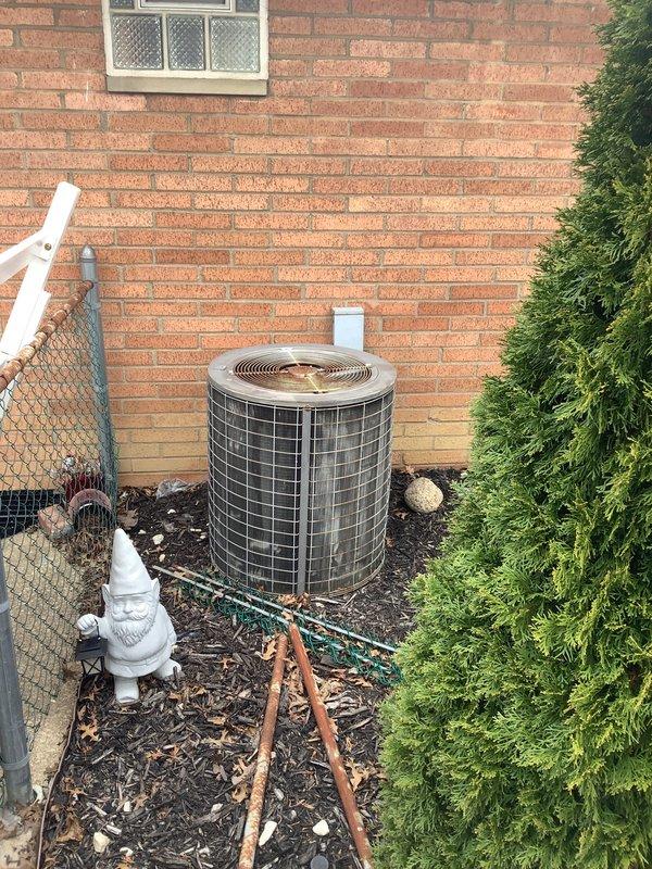 Completed on-site evaluation of existing older furnace and air conditioning system for replacement estimate. Assessed current basement-mounted furnace unit and outdoor condenser positioned against brick exterior wall, documenting equipment condition, installation configuration, and necessary replacement specifications for both heating and cooling systems.