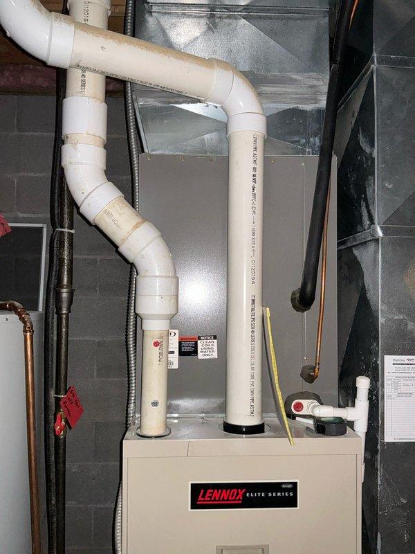 Conducted on-site evaluation of existing 26-year-old furnace system for replacement estimate. Assessed current Lennox Elite Series heating unit installation in basement location, documenting equipment condition, ductwork configuration, venting system with PVC exhaust pipes, electrical connections via armored conduit, gas line routing, and existing plenum assembly to provide accurate replacement specifications and scope of work.