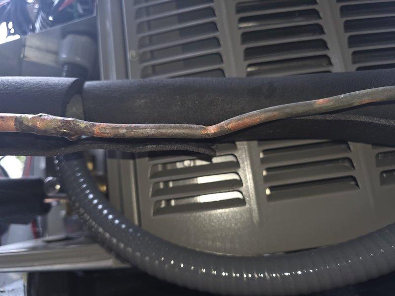 Responded to no cooling call with thermostat displaying E107 error code following recent PCB installation. Upon inspection, discovered severely corroded copper refrigerant line at outdoor unit, indicating moisture intrusion and potential refrigerant leak. Performed system diagnostics, checked electrical connections at control board, and assessed refrigerant line integrity to determine root cause of thermostat communication failure and system malfunction.