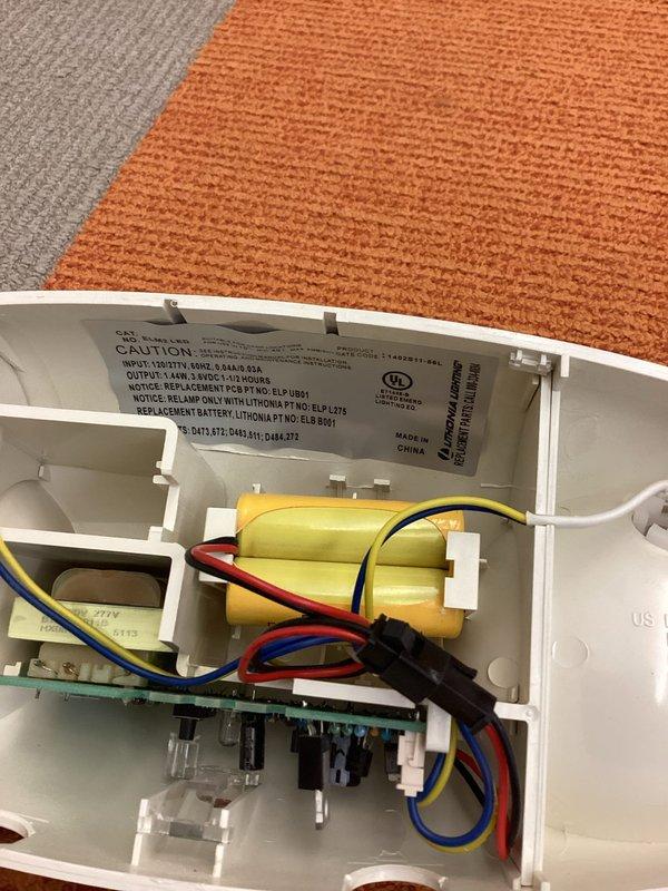 Responded to service call for non-operational emergency egress light fixture. Upon inspection, opened the dual-head LED emergency light unit and identified failed battery pack as the cause of malfunction. Replaced defective battery assembly, tested fixture operation to confirm proper illumination during emergency mode, reassembled housing, and verified unit functionality with indicator light confirmation.
